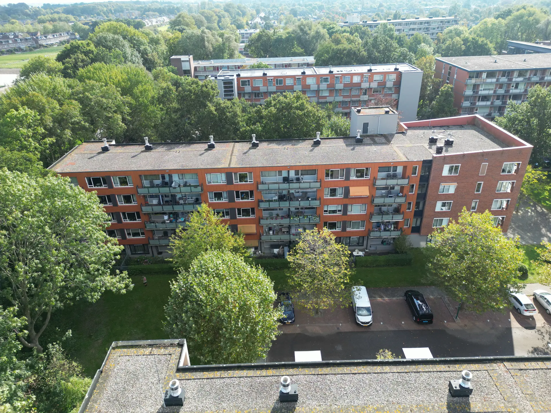 Appartementencomplex Narcissenlaan 3 t/m 65 blok 2 met balkonwoningen, omringd door bomen en geparkeerde auto's op de voorgrond.